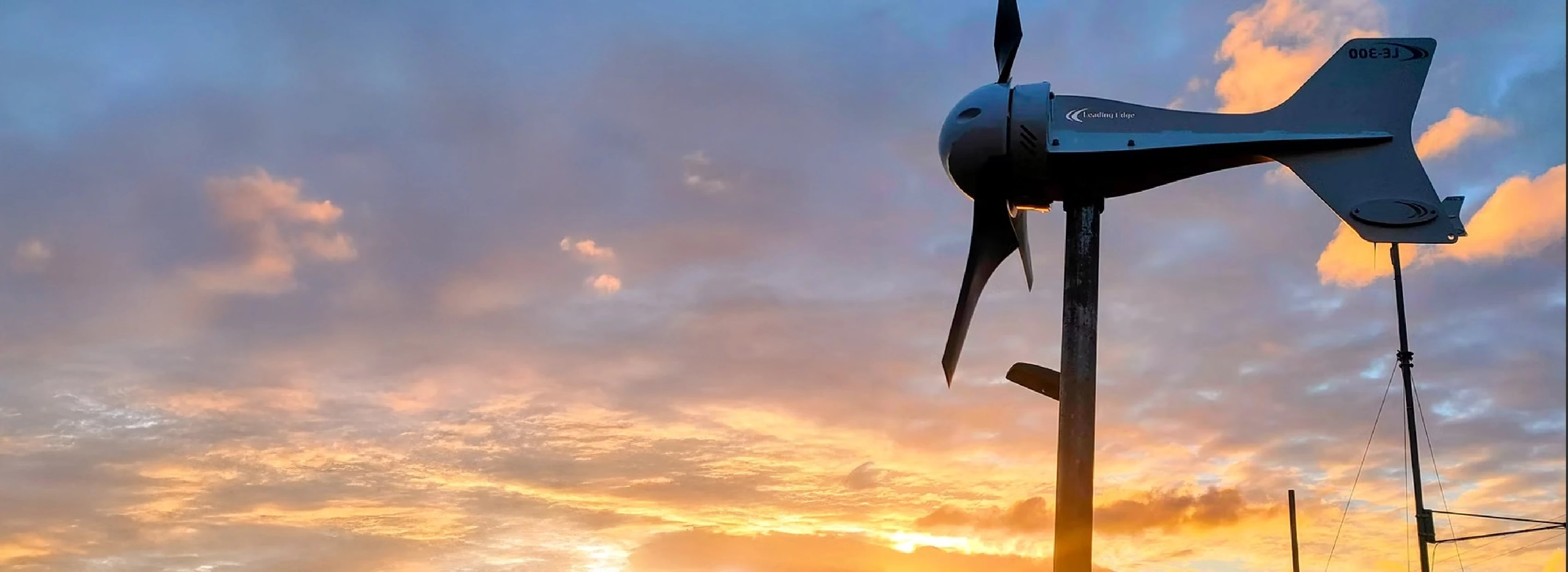Leading Edge wind turbine at dusk powering remote equipment